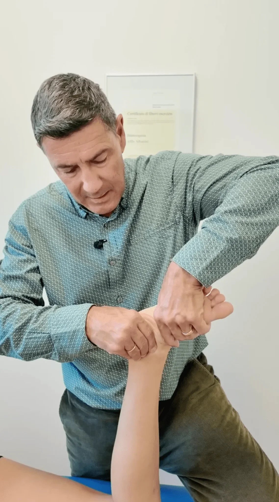Kinésithérapeute pratiquant la neurodynamique sur la cheville d’un patient en cabinet