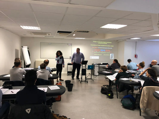 Formation en kinésithérapie Kpten, salle de classe avec participants et présentation sur écran.