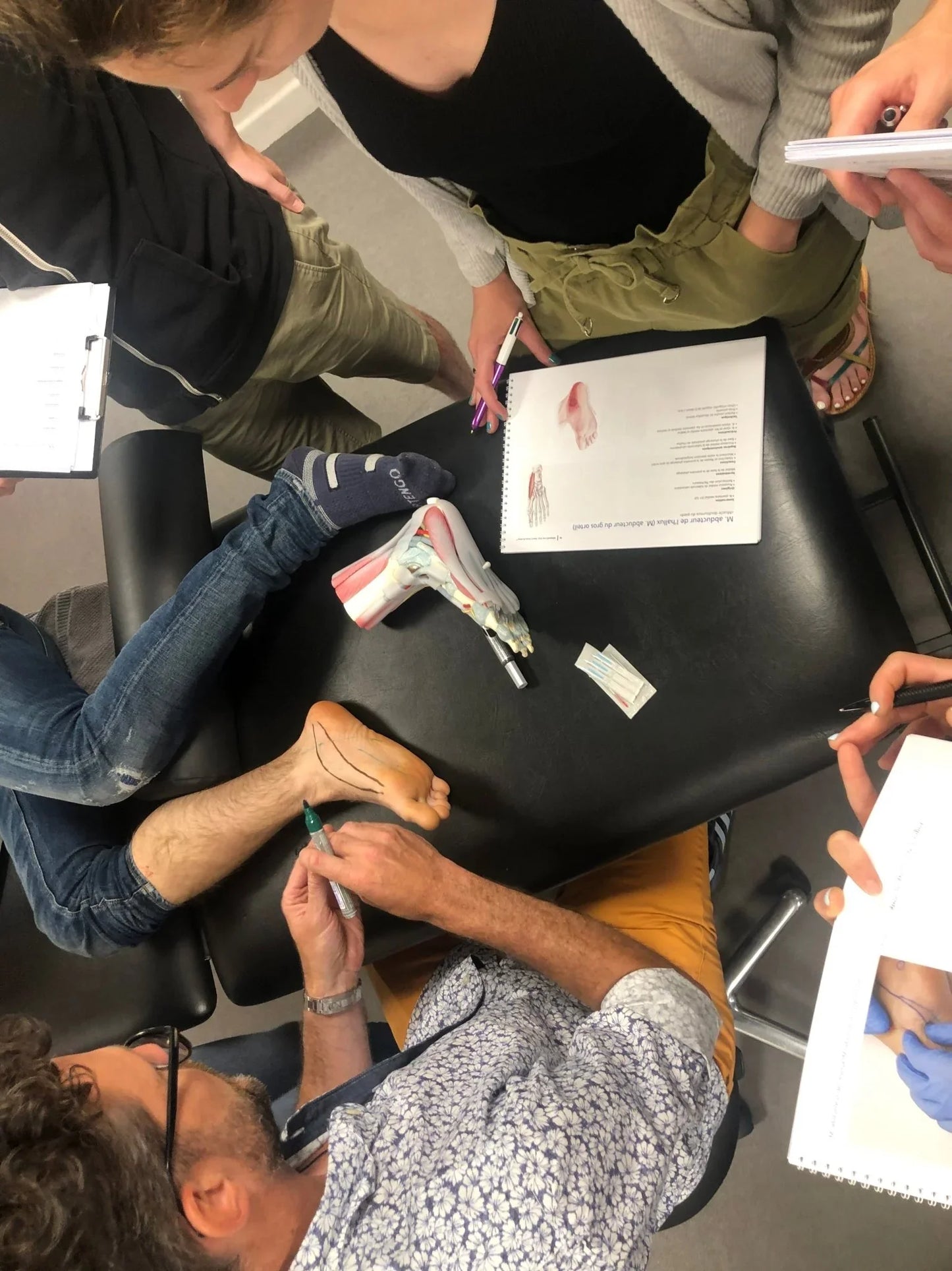 Session de formation en kinésithérapie dry needling sur le pied avec étudiants et supports visuels
